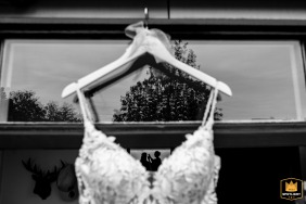 In Rijnsburg, the Netherlands, a unique portrait captures the bride and her makeup artist framed through the sheer fabric of the wedding dress while they prepare.